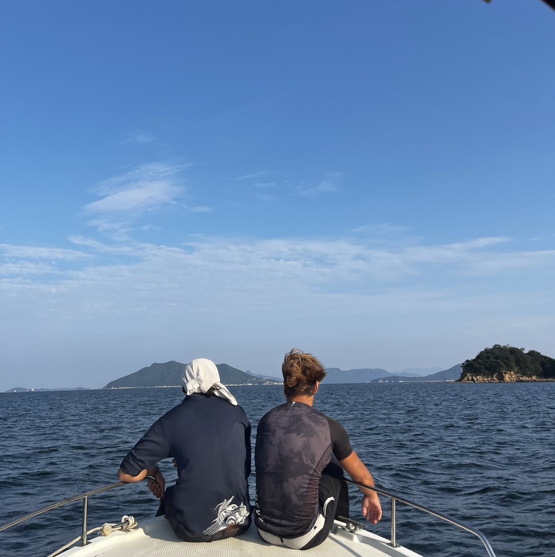 瀬戸内海を背に船首で座っているWithの社員